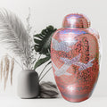 Decorative urn with bird designs on a white background