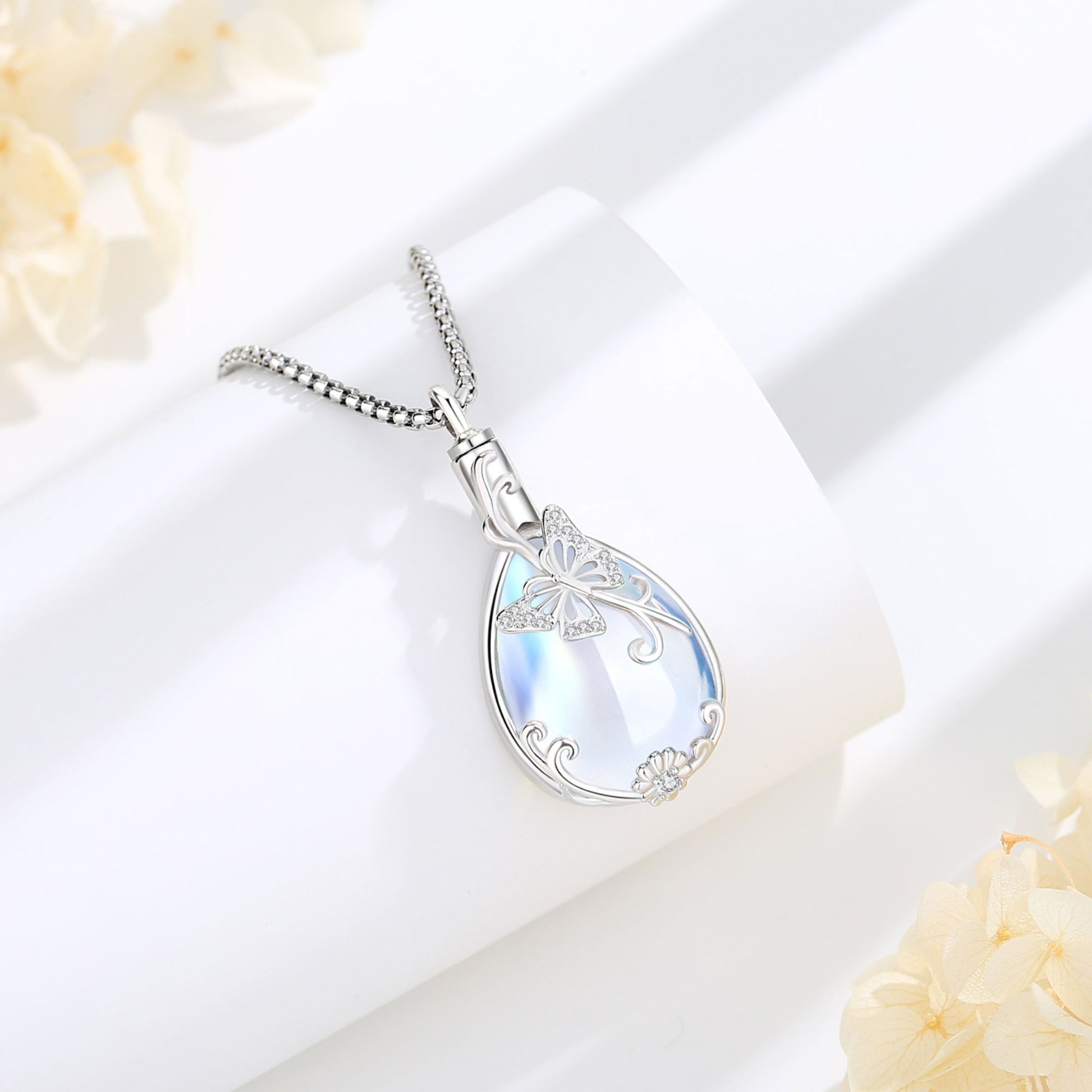 Silver necklace with a teardrop-shaped pendant on a soft white background
