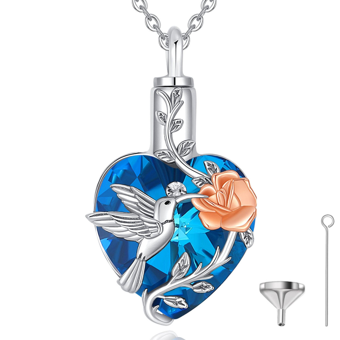 Heart-shaped pendant with blue gem, silver hummingbird, rose, and floral design on a white background.