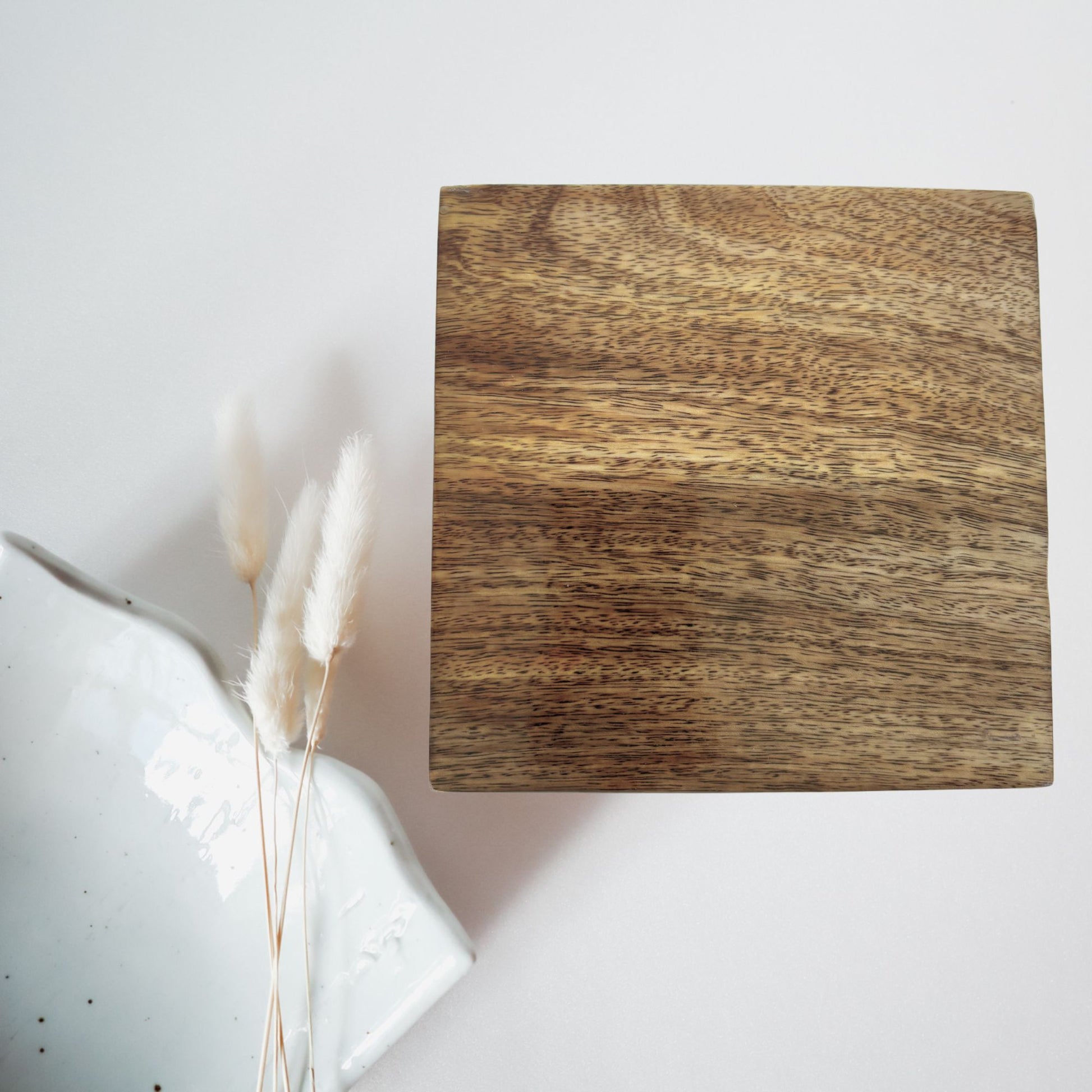 Wooden square block on a light gray background with decorative elements