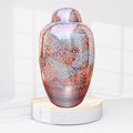 Decorative urn with bird designs on a white background