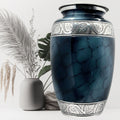 Blue marble-patterned urn with silver detailing on a white background