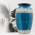 Blue ceramic urn with decorative patterns on a white background