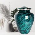 Teal urn with silver lid on a white background