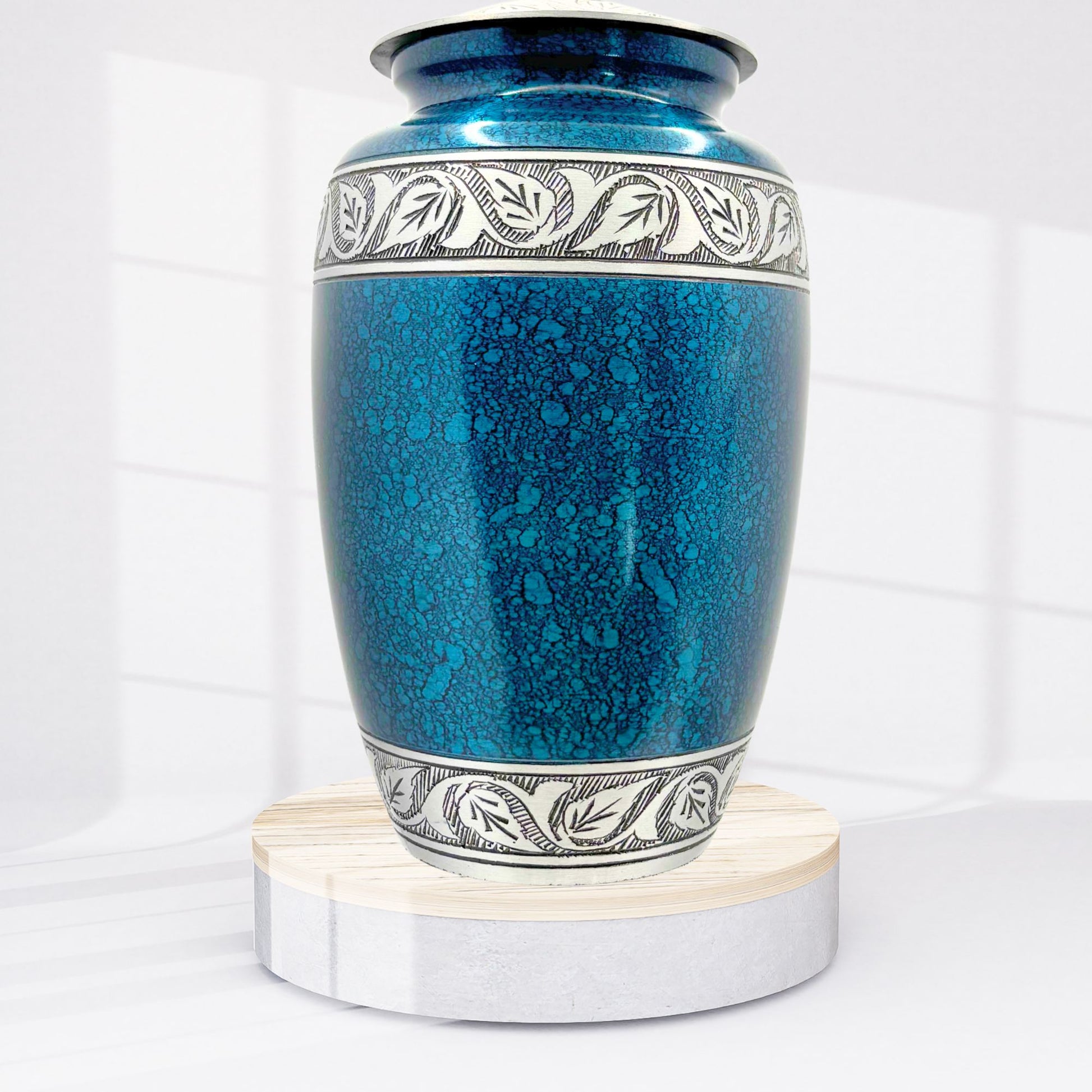 Blue ceramic urn with silver decorative band on a white background