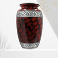 Red and black patterned urn with silver decorative band on a white background