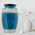 Blue ceramic urn with decorative patterns on a gray background