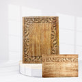 Wooden decorative panel with intricate carvings on a white background