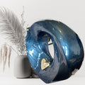 Blue marble-like decorative Urn with a gold heart on a white background