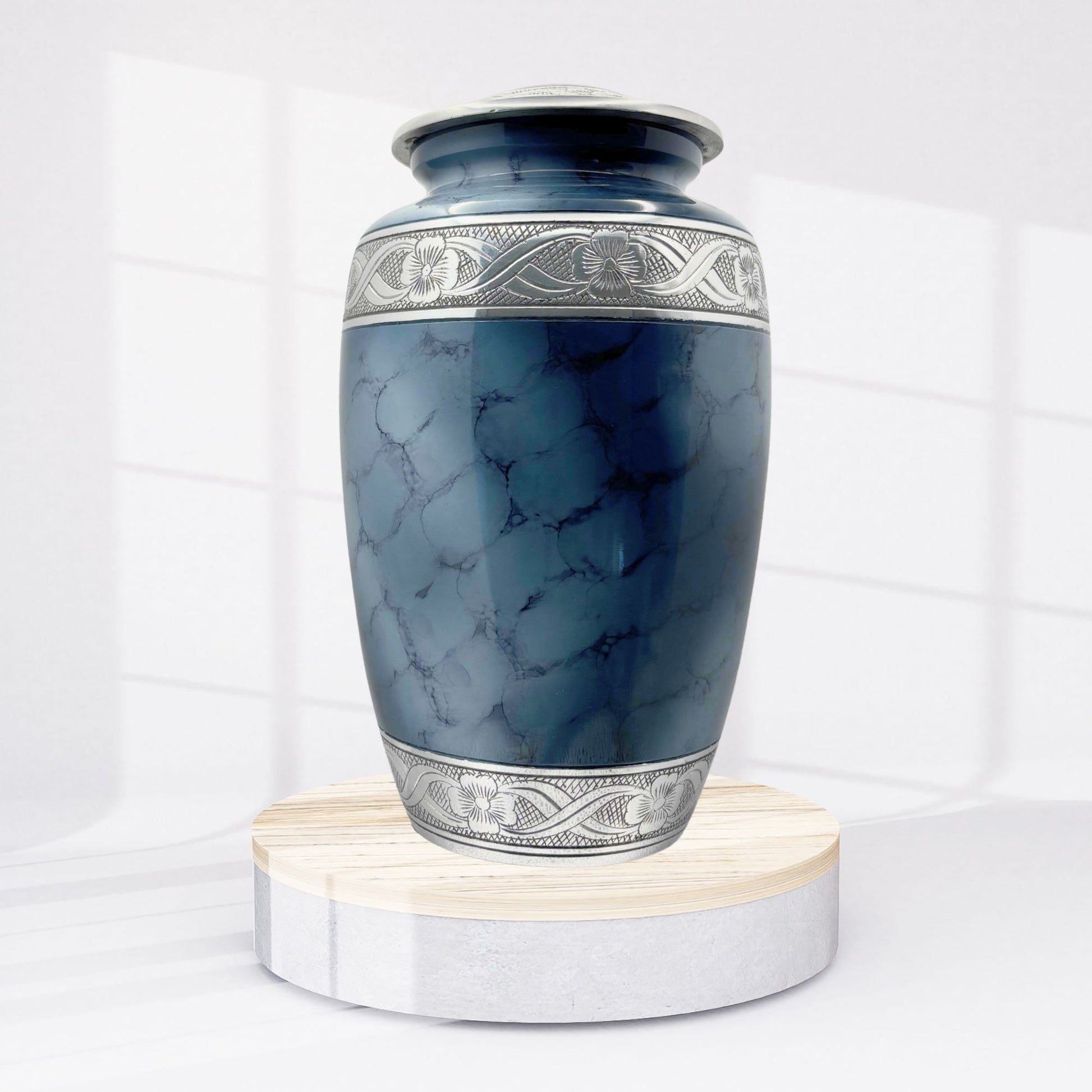Blue marble-patterned urn with silver decorative band on a white background