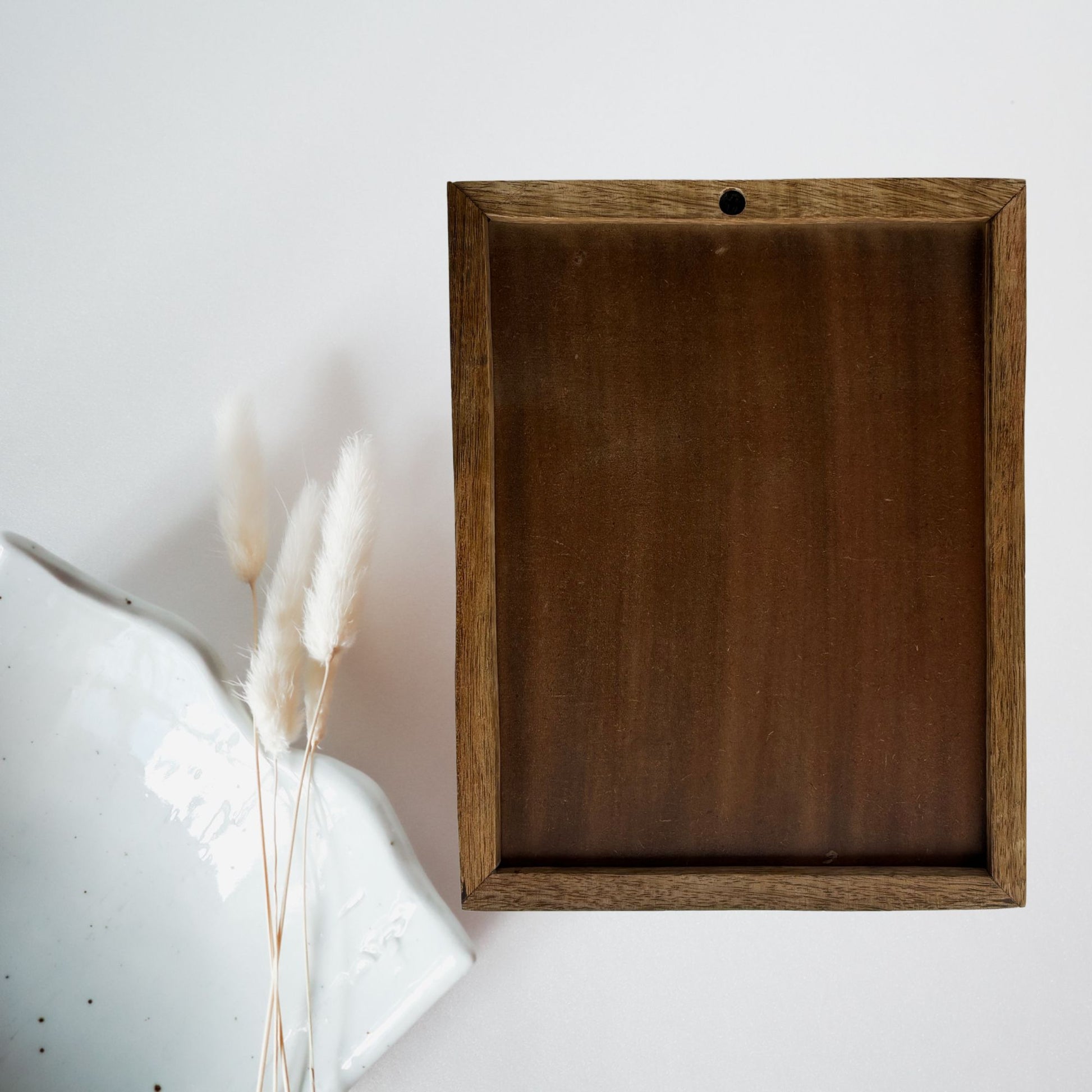Wooden frame on a white wall with decorative elements