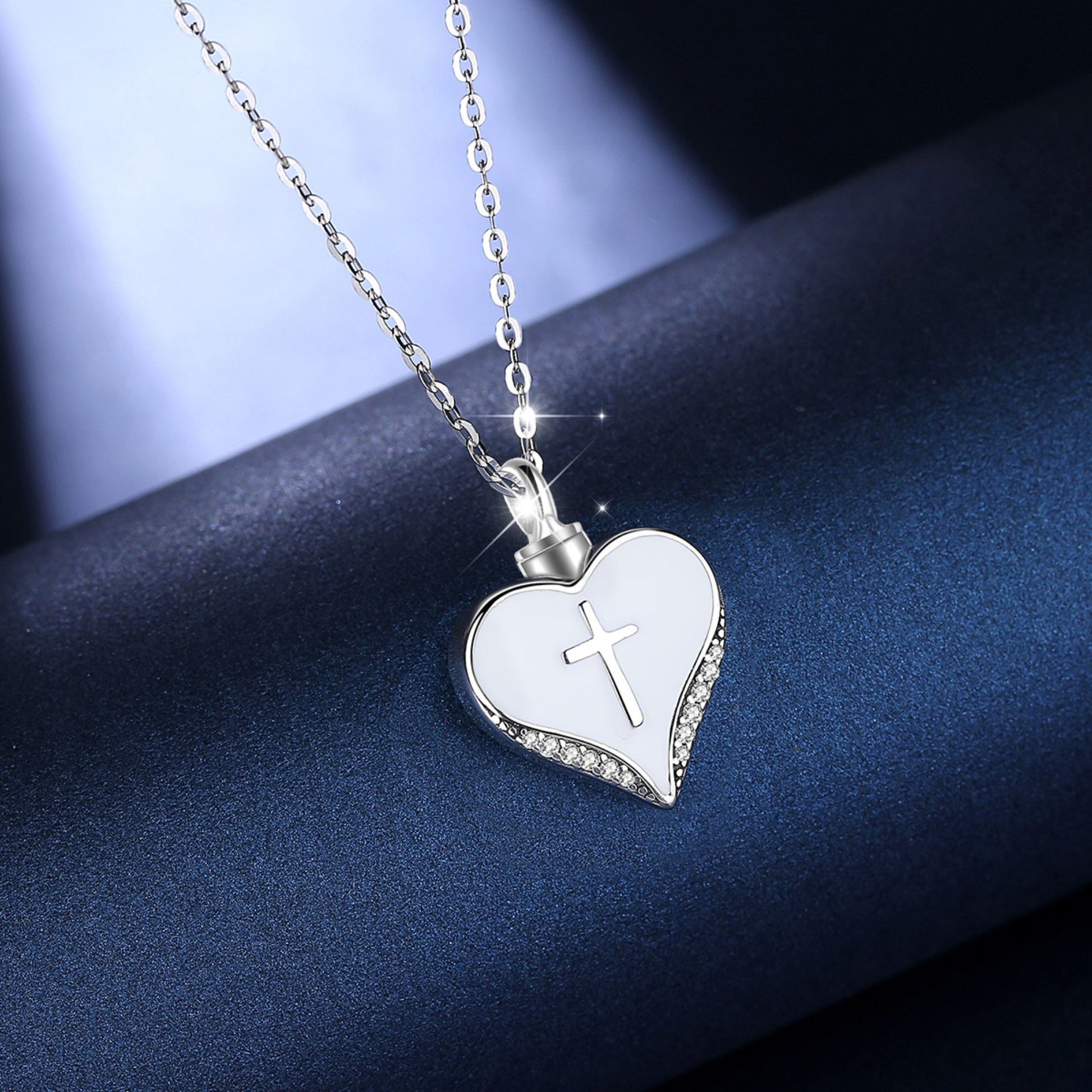 Heart-shaped pendant with a cross on a chain against a dark background