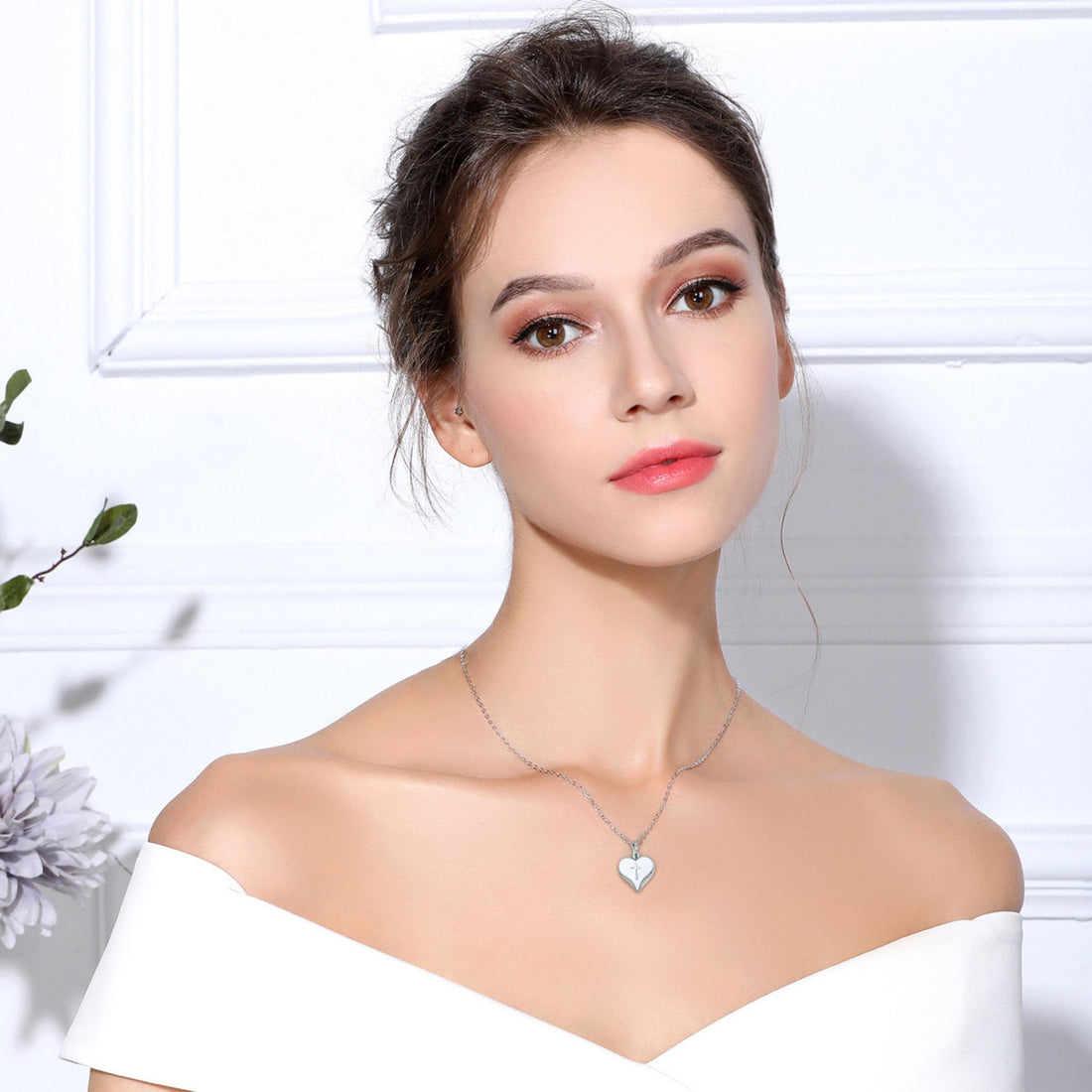 Heart-shaped pendant with cross design on a white background