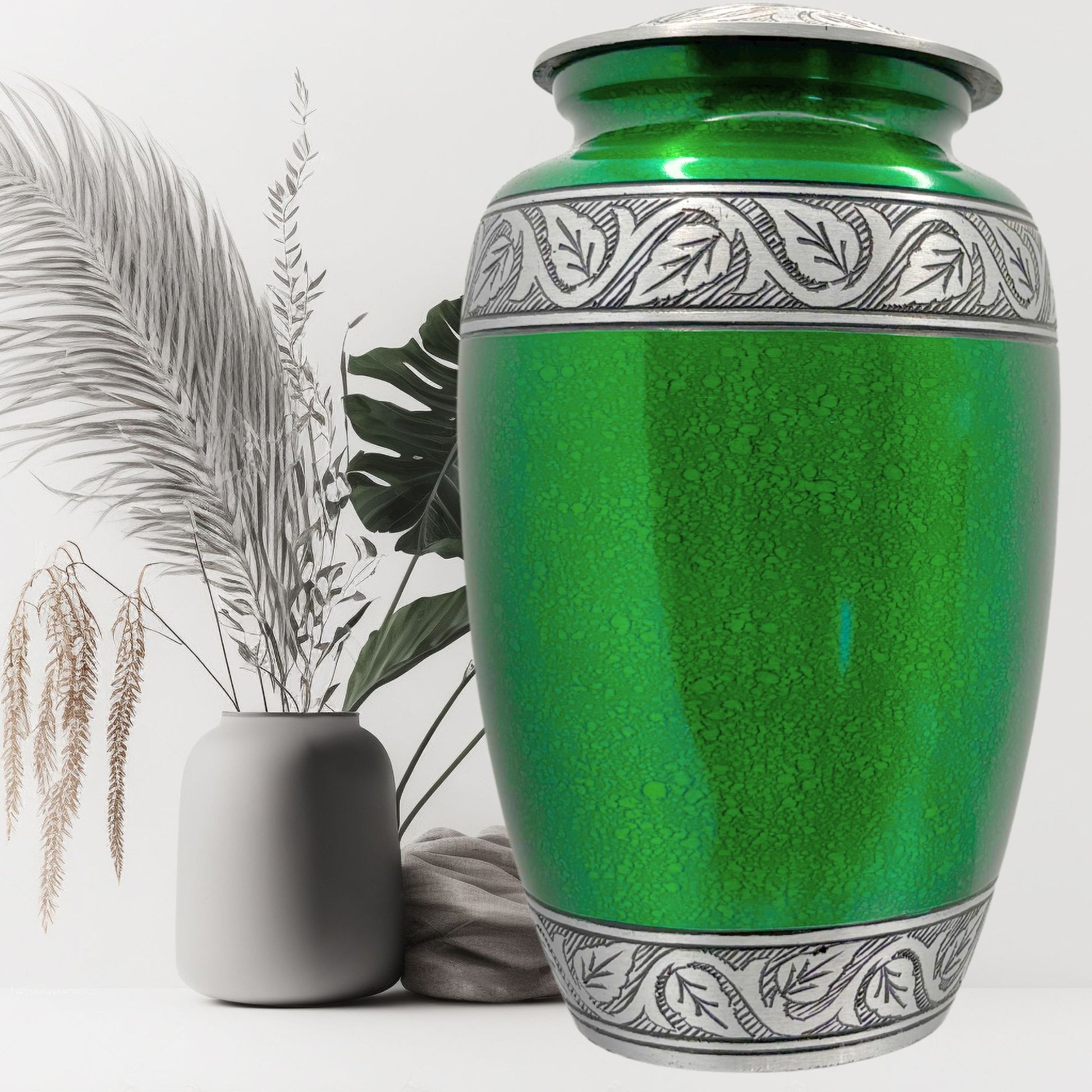 Green urn with silver patterns on a white background