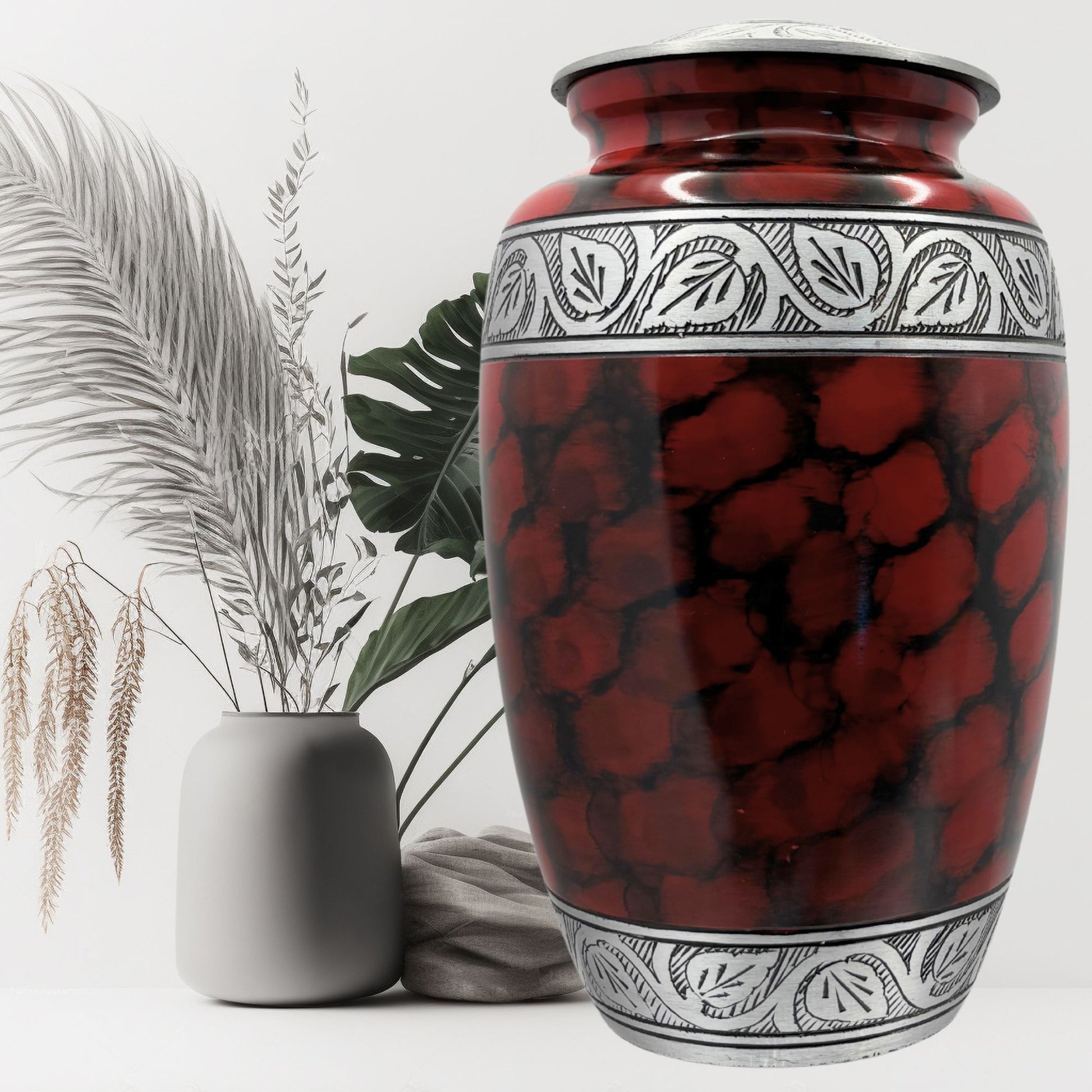 Red and black patterned urn with decorative elements on a white background