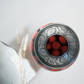 Decorative container with red marble design on a white background