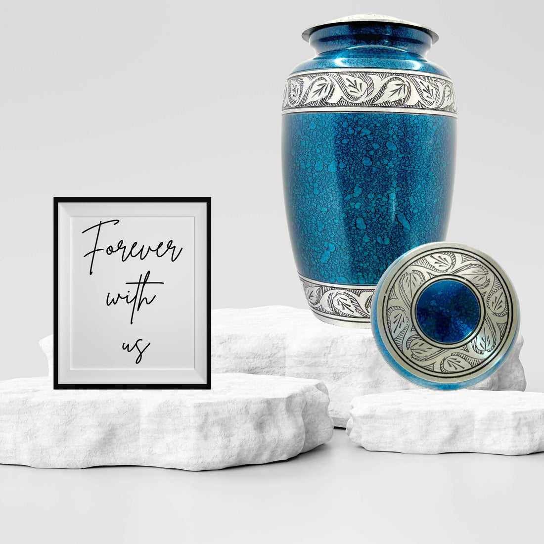 Blue ceramic urn with silver decorative patterns on a white background