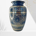Decorative blue and gold vase with intricate patterns on a white background