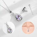 Jewelry set with a heart-shaped and teardrop-shaped pendant on a white background.