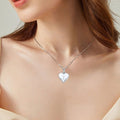 Silver heart-shaped necklace on a model with a neutral background