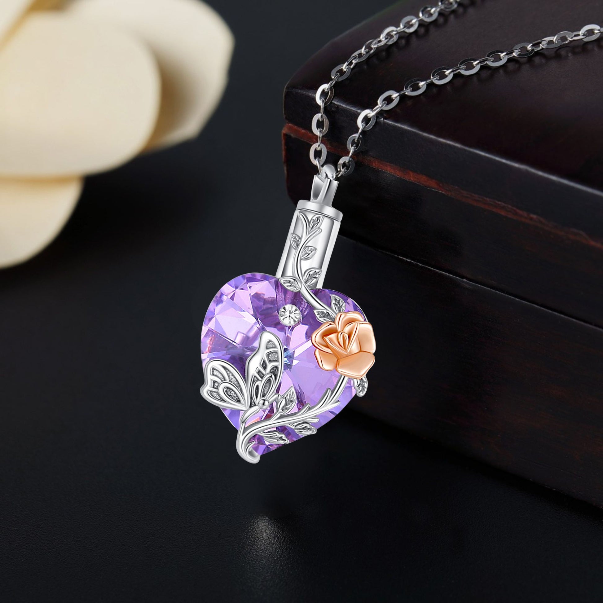 Heart-shaped purple pendant with floral design on a dark surface